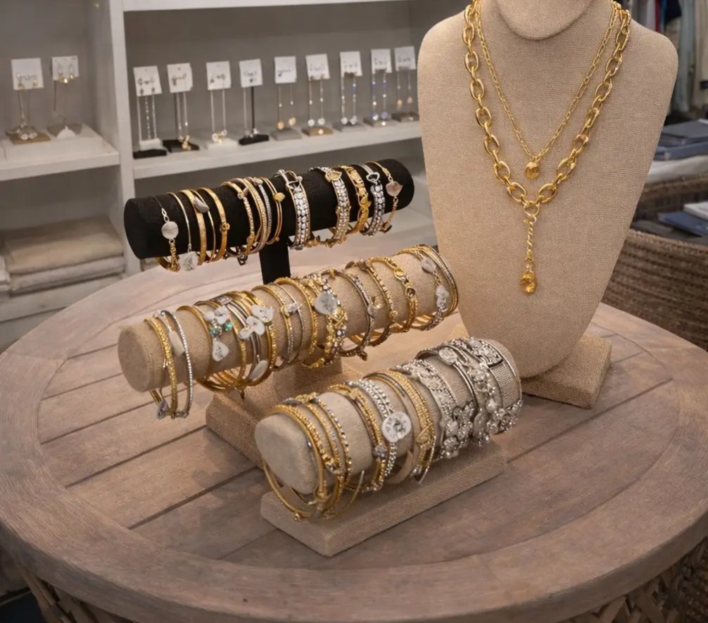 A display of gold and silver bracelets, beaded bangles and layered chain necklaces on a linen bust at Longboat Resort Wear